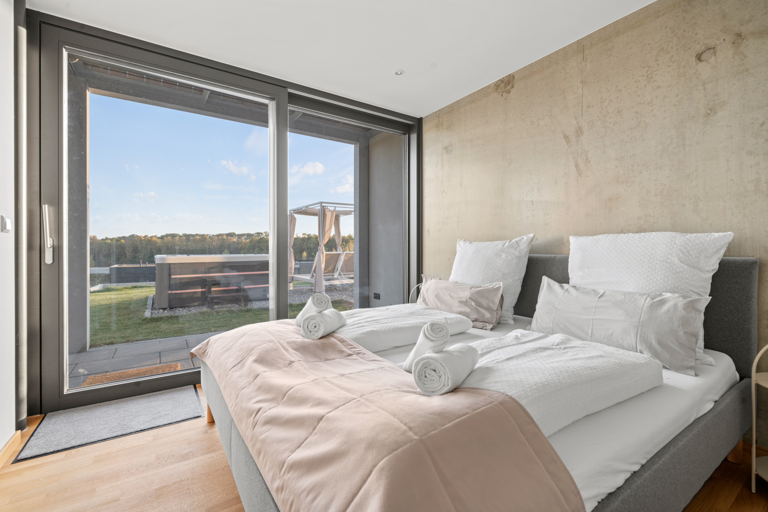 Doppelbett im ebenerdig erreichbaren EG-Zimmer mit Blick in den Garten und auf den Whirlpool